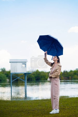 Woman under summer rain, holding umbrella, weather forecast and rainy atmosphere.