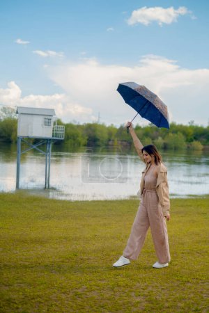 Paraguas en la mano de la mujer mientras corre, lluvia ligera de verano, paraguas simboliza descuentos estacionales y ofertas especiales.