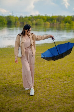 Umbrella in woman's hand as she runs, light summer rain, umbrella symbolizes seasonal discounts and special offers.