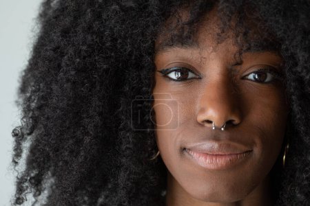 Photo for Face of young smiling african girl with piercing in nose and afro hairstyle. Extreme close up of the face portrait - Royalty Free Image