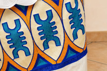 Nahaufnahme eines lebendigen afrikanischen Textildesigns mit komplizierten Stickereien und kühnen geometrischen Mustern, das das reiche kulturelle Erbe und die Handwerkskunst präsentiert