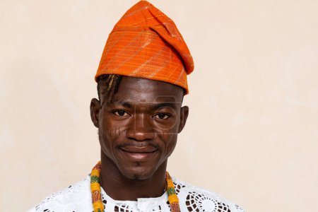 Portrait of a proud African man wearing a traditional orange head wrap and white embroidered outfit, capturing his confidence and cultural heritage