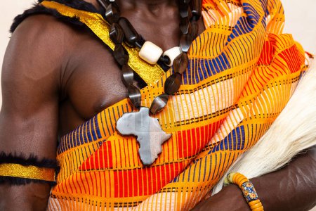 Detailaufnahme, die die reiche Textur und die lebendigen Farben eines traditionellen afrikanischen Kleidungsstücks und komplizierten handgefertigten Schmucks zeigt, der kulturelles Erbe und Handwerkskunst symbolisiert