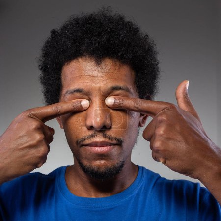 Una imagen de primer plano de un individuo con los dedos presionados contra sus ojos cerrados, que representa un posible dolor ocular o la carga de estrés intenso