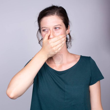 Porträt einer Person mit der Hand auf der Wange, sichtbar in Bedrängnis, eine häufige Reaktion auf akute Zahnschmerzen oder Zahnbeschwerden