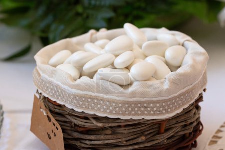 a rustic basket filled with traditional white sugared almonds, a sweet favor for a wedding celebration