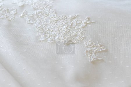 die exquisite Stickerei auf einem Brautstoff, die die komplizierten Spitzendetails eines Hochzeitskleides einfängt