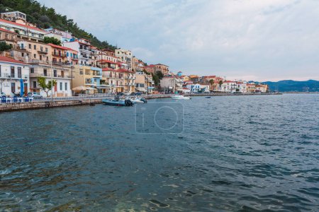 el tranquilo paseo marítimo de un pueblo mediterráneo bordeado de coloridos edificios y barcos de recreo amarrados a lo largo del claro agua azul