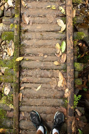 Foto de De pie sobre un antiguo puente cubierto de musgo en el corazón del bosque, rodeado de hojas caídas y los sonidos de un arroyo que gotea - Imagen libre de derechos