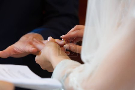 Foto de El momento íntimo como la novia coloca un anillo de bodas en el dedo del novio, simbolizando el amor eterno - Imagen libre de derechos