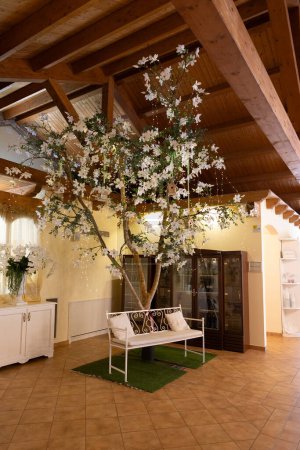 Photo for A cozy indoor wedding space adorned with stunning artificial cherry blossoms, bringing a touch of spring indoors - Royalty Free Image