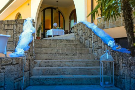 la entrada a un lugar de la boda se adorna con el tul azul que fluye y una linterna clásica, fijando un tono celebratorio