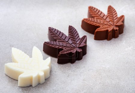 CBD infused chocolates. Delicious mood food, desserts and treats with a twist.Dark, milk and white chocolate on grey background