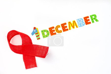 Téléchargez les photos : 1er décembre écrit en lettres colorées sur fond blanc avec ruban de sensibilisation rouge - en image libre de droit