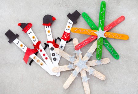  Artisanat de Noël avec bâtonnets de glace. Petits bonhommes de neige aux ornements étoilés ou flocons de neige
