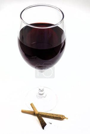 Téléchargez les photos : Marijuana joint et verre de vin rouge sur blanc - en image libre de droit