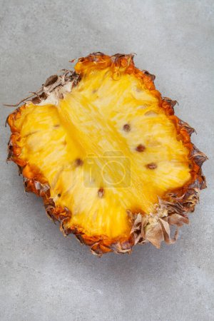 Photo for Spoilt pineapple, cut in half. On mottled grey with copy space - Royalty Free Image