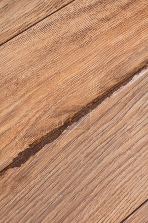 Wooden laminate flooring with water damage. Close up of join with damage