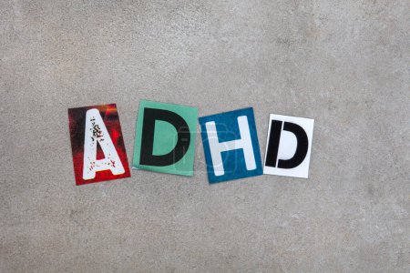 ADHD written in magazine cutout letters on mottled grey