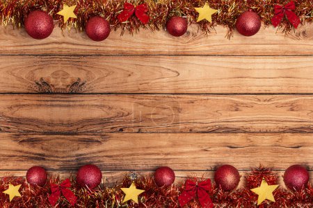 Foto de Guirnaldas decorativas de bronce dorado de Navidad, bolas de Navidad sobre fondo rústico de madera. Plano, vista superior, espacio para copiar - Imagen libre de derechos