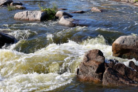 Nahaufnahme des Wassers fließt schnell über Felsbrocken in rauem Fluss