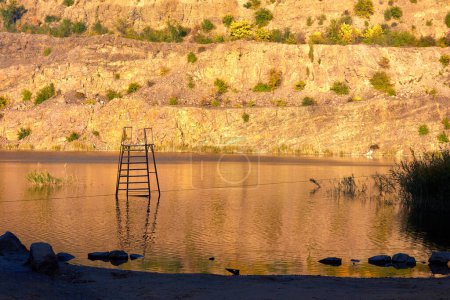 Radon Lake in former abandoned granite quarry full with pure transparent water at sunset. Ukraine, Migeia.