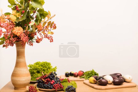 Photo for Autumn composition vase, berries, fruits, vegetables on the table in the kitchen. High quality photo - Royalty Free Image