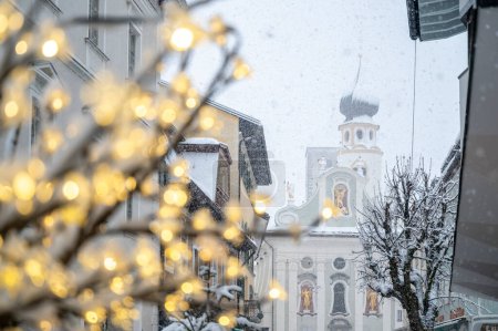 Téléchargez les photos : Gros plan de l'arbre avec des lumières de Noël sur la rue enneigée - en image libre de droit