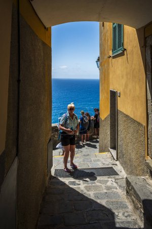 Téléchargez les photos : Gens marchant sur la belle vieille rue de la ville côtière, Cinque Terre, Corniglia - en image libre de droit