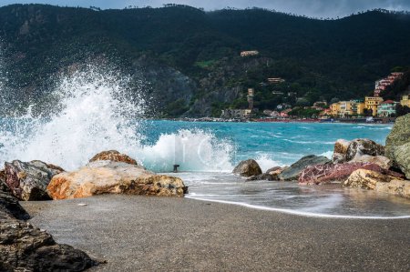 Foto de Olas rompiendo en la costa rocosa del mar. Cinque Terre. Monterosso, el puerto, la playa y el antiguo pueblo - Imagen libre de derechos