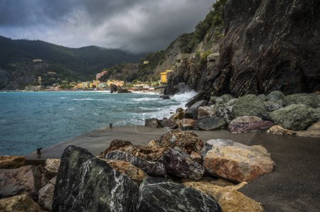 Foto de Olas rompiendo en la costa rocosa del mar. Cinque Terre. Monterosso, el puerto, la playa y el antiguo pueblo - Imagen libre de derechos