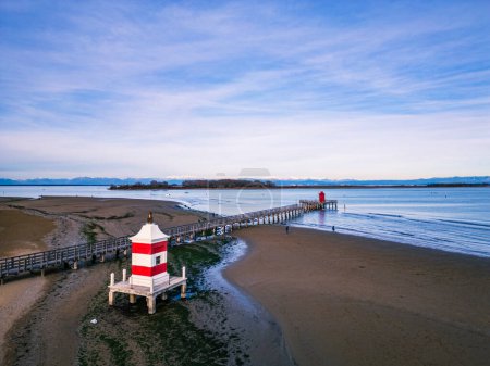 The beach of Lignano Sabbiadoro and its historic lighthouses.