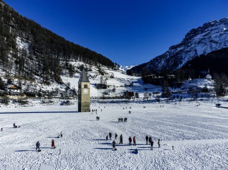Winter landscapein the Alps with the famous sunken church tower in Reschensee (Resia lake) on the border between the South Tyrol (Italian Alps) and Austria.