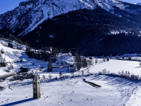 Winter landscapein the Alps with the famous sunken church tower in Reschensee (Resia lake) on the border between the South Tyrol (Italian Alps) and Austria.