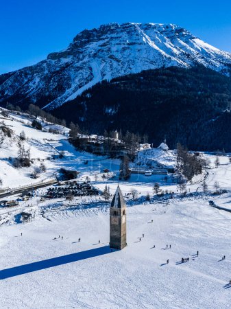 Winterlandschaft in den Alpen mit dem berühmten versunkenen Kirchturm in Reschensee an der Grenze zwischen Südtirol (Italienische Alpen) und Österreich.