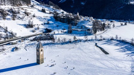 Paisaje invernal en los Alpes con la famosa torre de la iglesia hundida en Reschensee (lago Resia) en la frontera entre el Tirol del Sur (Alpes italianos) y Austria.