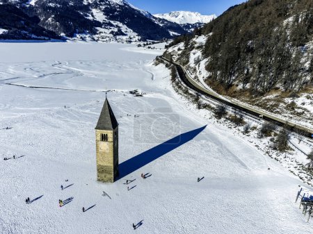 Paisaje invernal en los Alpes con la famosa torre de la iglesia hundida en Reschensee (lago Resia) en la frontera entre el Tirol del Sur (Alpes italianos) y Austria.
