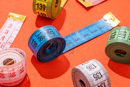 Foto de Concepto de dieta. coloridas cintas métricas vista superior sobre fondo rojo brillante, disposición plana, patrón - Imagen libre de derechos