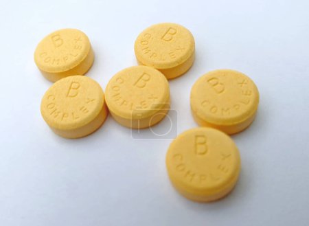 Großaufnahme von Vitamin B-Komplex gelben Pillen isoliert auf weißem Hintergrund. Nahrungsergänzungsmittel und Gesundheitskonzept.