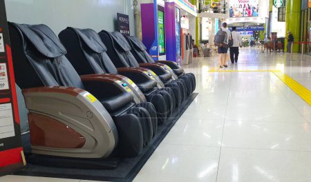 Téléchargez les photos : Jakarta, Indonésie - 09 mai 2023 : Chaise de massage électrique en cuir pour usage public à Stasiun Gambir, Jakarta Indonésie. Relaxation automatique de la pression d'air fauteuil de massage distributeur automatique. - en image libre de droit