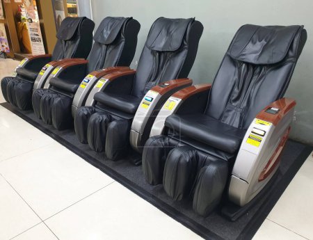 Téléchargez les photos : Une rangée de chaises de massage électriques à usage public à Stasiun Gambir, Jakarta Indonésie. Installation publique de relaxation, de repos et de soins de santé concept. - en image libre de droit