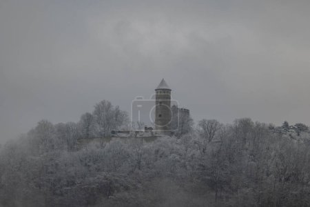 Photo for Medieval castle ruins covered with snow on a mountain in winter forest. Plesse castle near Goettingen, Germany - Royalty Free Image