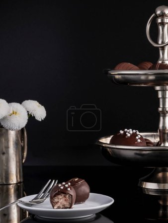 Photo for Noble marzipan chocolates beautifully arranged on an etagere decorated with vintage silver flower vase - Royalty Free Image