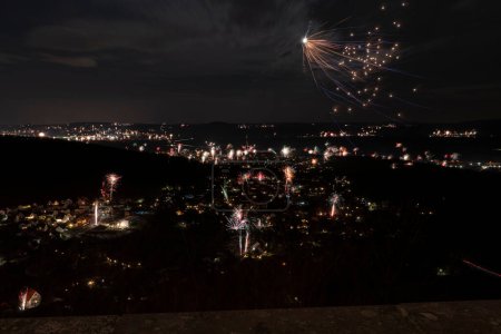 Photo for Night shot of a village with New Year's Eve fireworks with several rockets from bird's eye view - Royalty Free Image