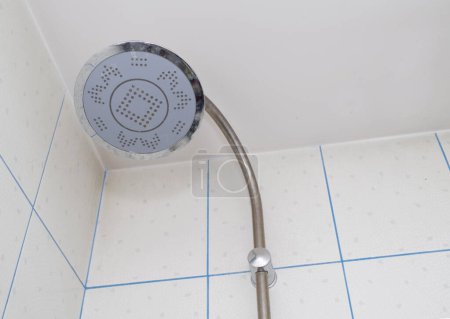 Téléchargez les photos : Douche pluie dans salle de bain blanche, carrelage blanc et coulis bleu - en image libre de droit