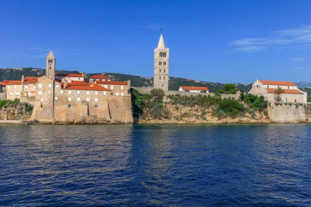 Téléchargez les photos : Vue depuis le bateau sur la vieille ville de Rab, quatre tours d'église historiques, symbole de la ville Croatie - en image libre de droit