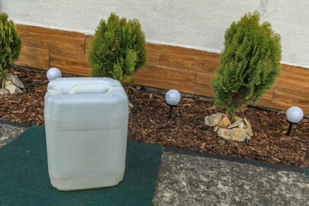 Productos químicos en un recipiente, fertilizante para regar plantas en el jardín, envenenamiento ambiental