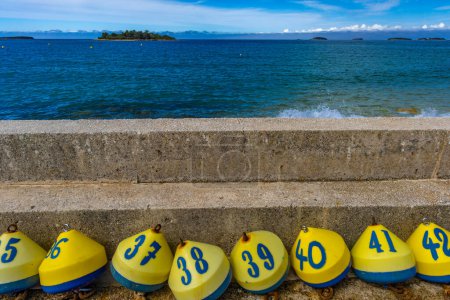 Ganar la lotería boyas de colores con números y letras en la orilla del mar Croacia Jadran
