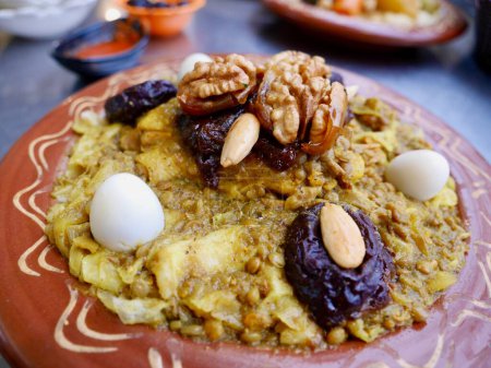 Téléchargez les photos : Gros plan de Rfissa, un plat marocain de poulet cuit, lentilles et oignons servis sur un lit de sperme râpé. Photo de haute qualité - en image libre de droit