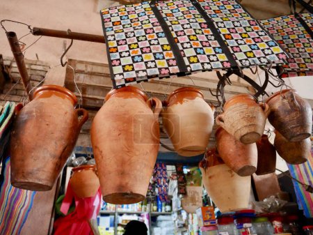Téléchargez les photos : Pots tanjia en terre cuite suspendus à un magasin dans le souk de Marrakech, Maroc. Photo de haute qualité - en image libre de droit